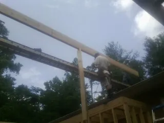 Carpenter setting a ridge beam over a new addition frame — Ice Dam Removal by Roofing Brothers in Gurnee