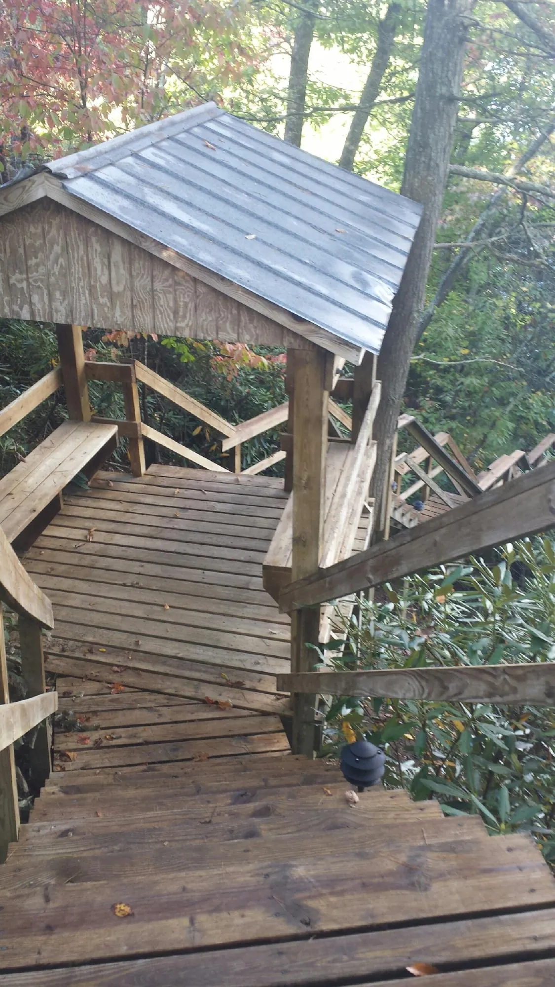 Metal roofed shelter over wooden steps on a wooded walkway — Skylight Repair & Installation work by our crew in Gurnee